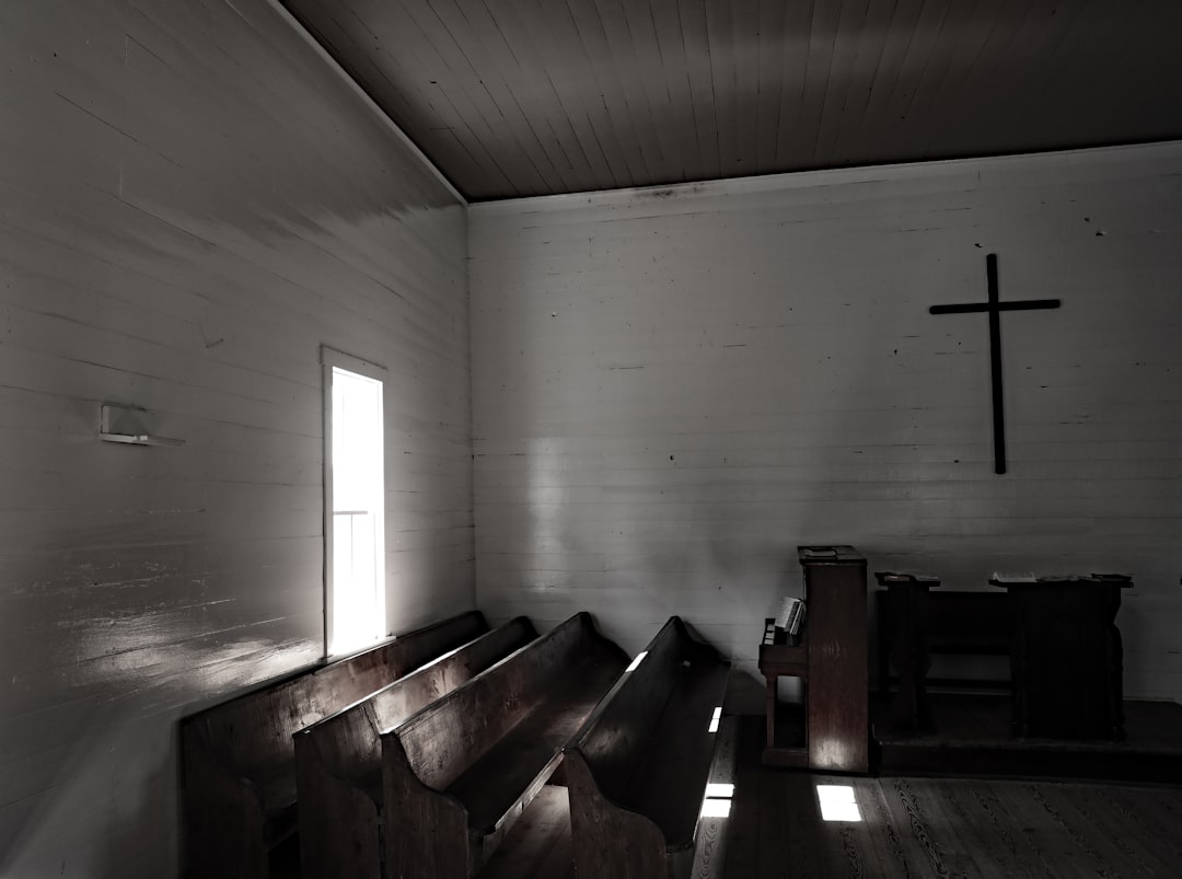 brown wooden bench near white wall