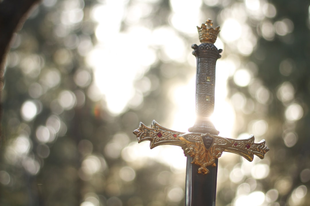 close-up photography of gold-colored and black sword